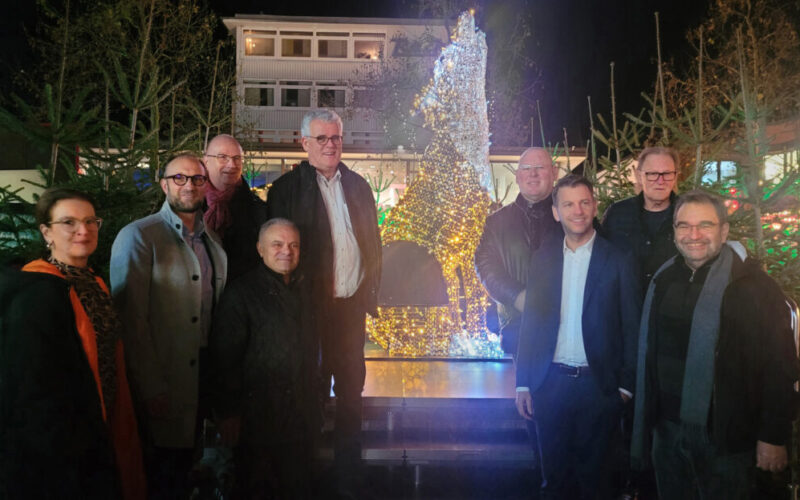 Eine Gruppe Menschen vor dem Fotopoint in Form eines beleuchteten Wolfs